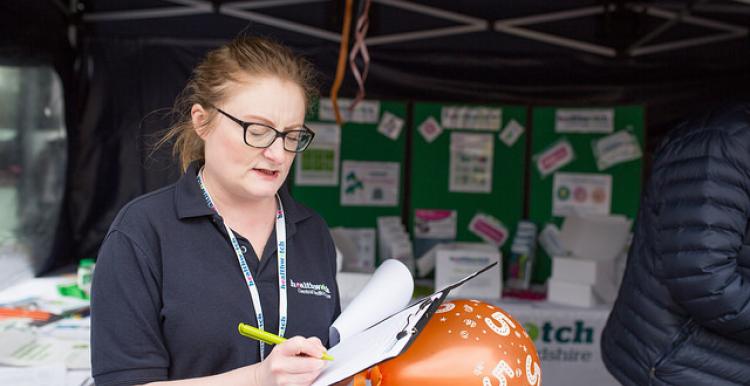 Healthwatch staff member taking down notes from a member of the public