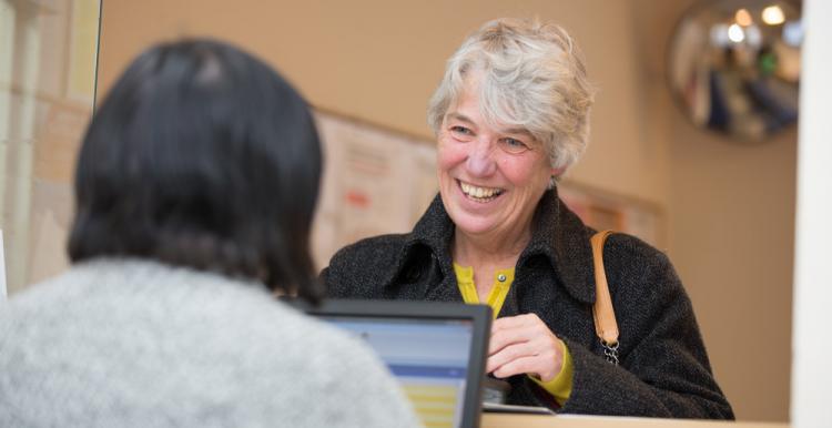 Female speaking to a receptionist