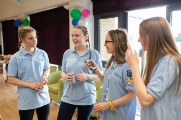 Four young females stood talking to each other