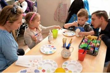 Family sat around a table doing a craft activity