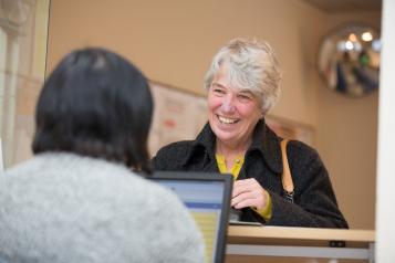 Female speaking to a receptionist