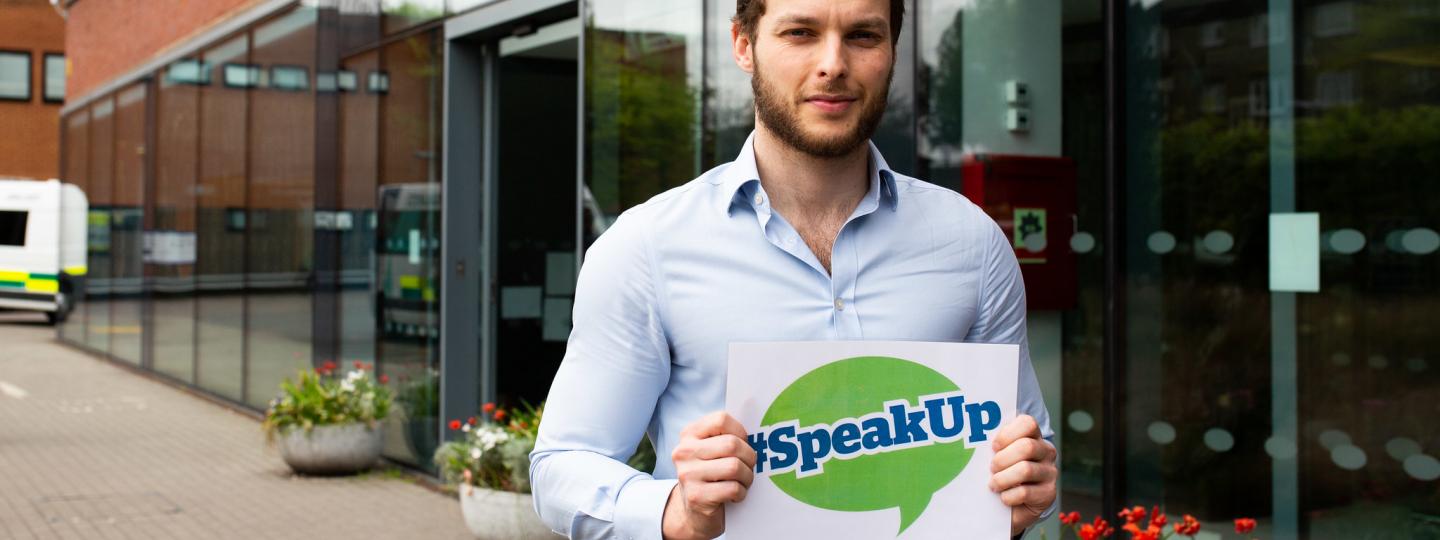 Man holding healthwatch speak up sign